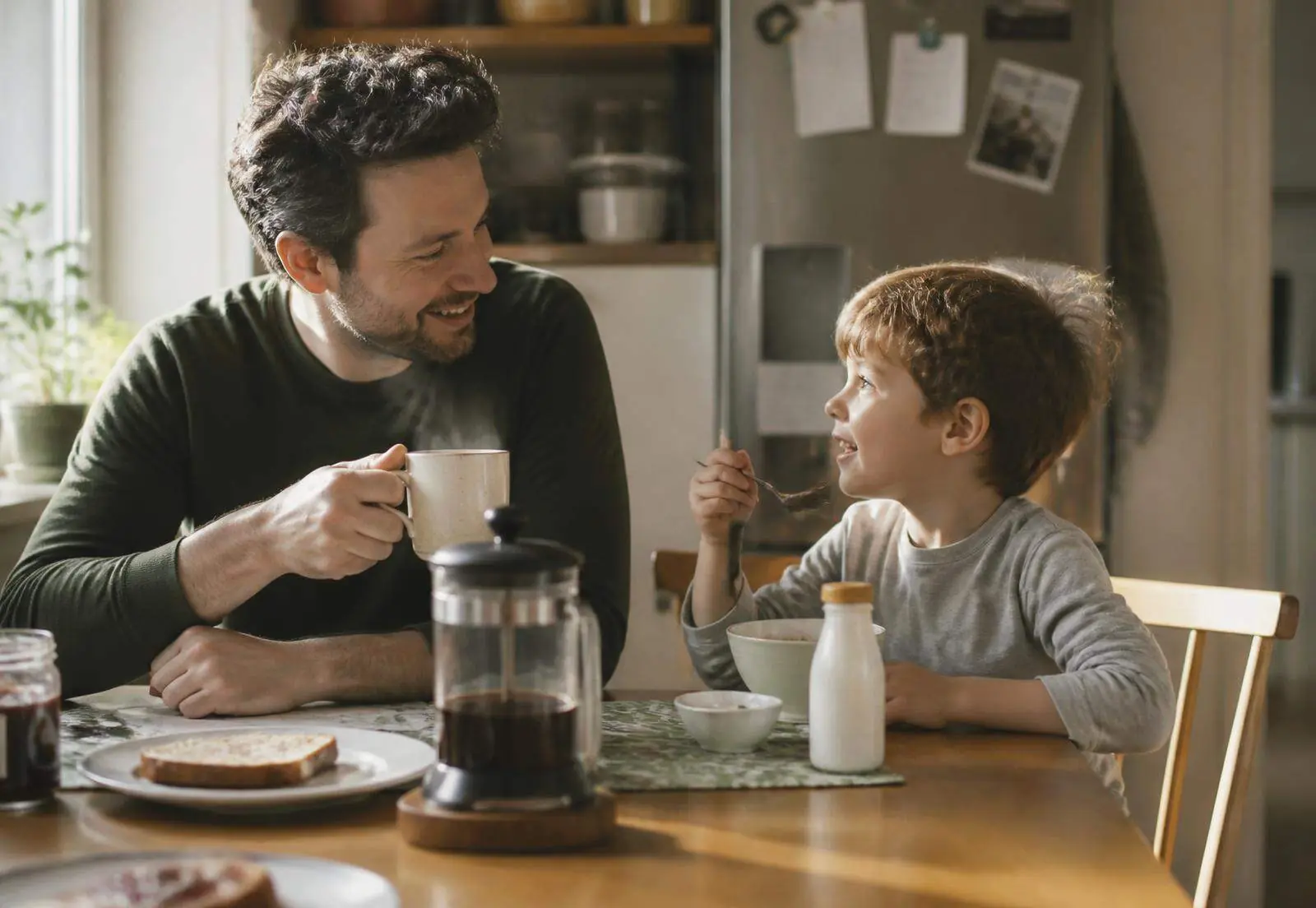 A father and son sharing breakfast at a sunlit kitchen table